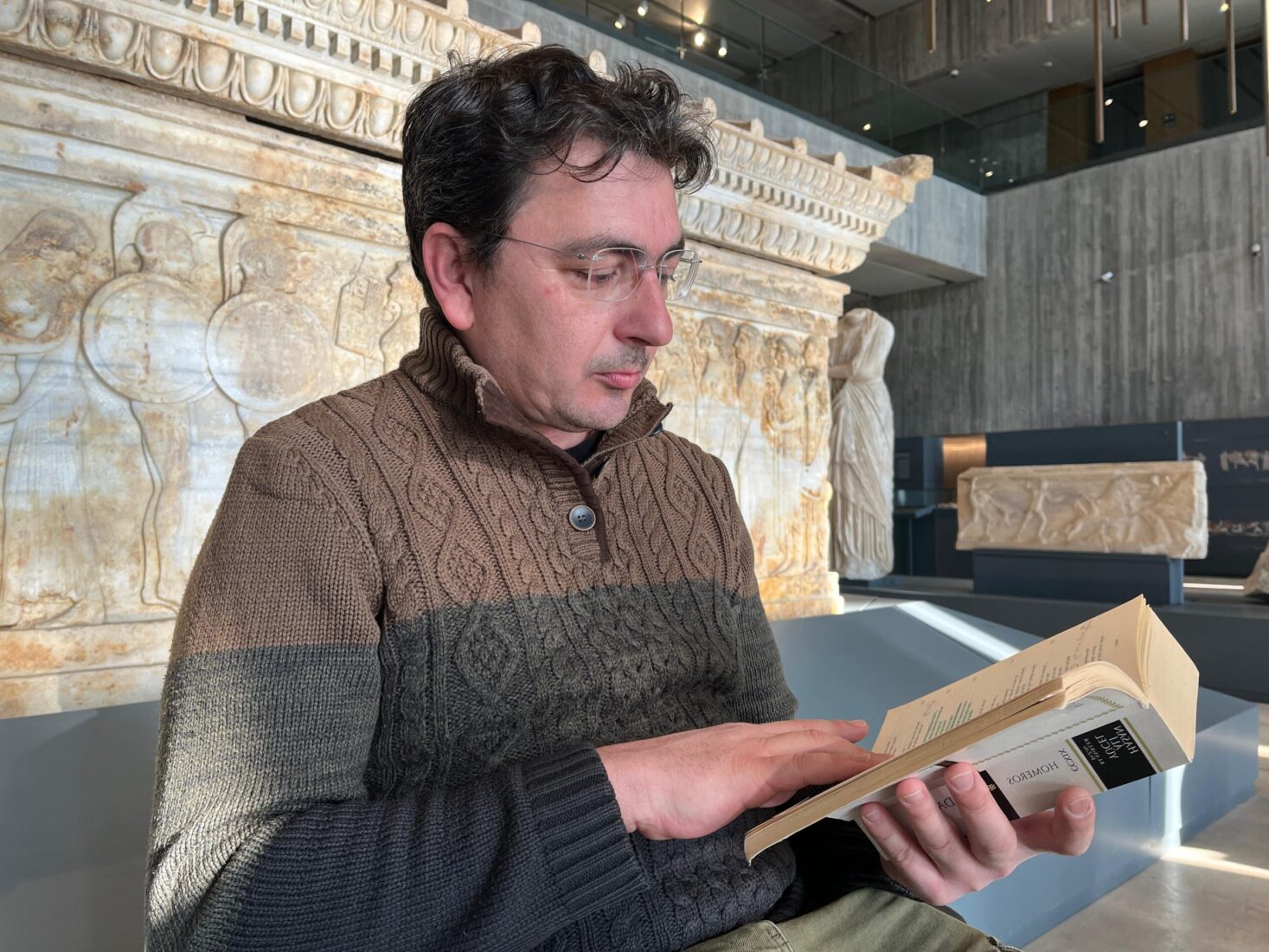 A participant reads Homer's Iliad in front of the Polyxena Sarcophagus, Troy Museum, Canakkale, Türkiye, March 21, 2025. (Photo via Troy Museum)
