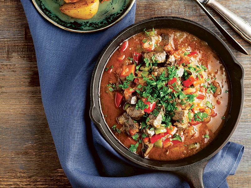 Slow-cooked beef cubes with red and green peppers and sweet chestnuts in a rich tomato base, served hot in a cast iron pan. (Courtesy of Yemek)