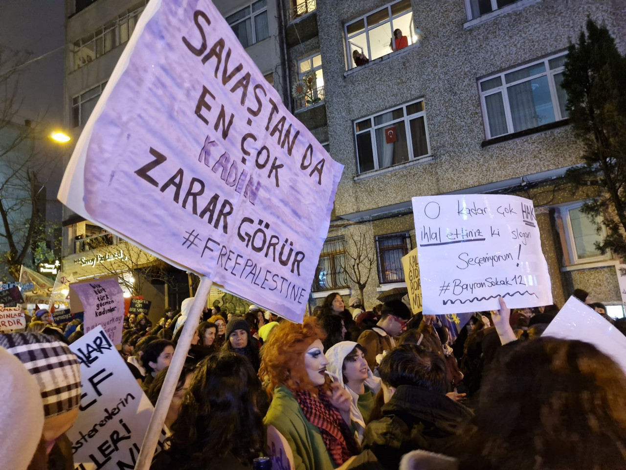A woman carries a banner during night march, stating that women suffer the most in times of war, expressing solidarity with Palestine, Istanbul, Türkiye, March 8, 2024. (Photo via X)