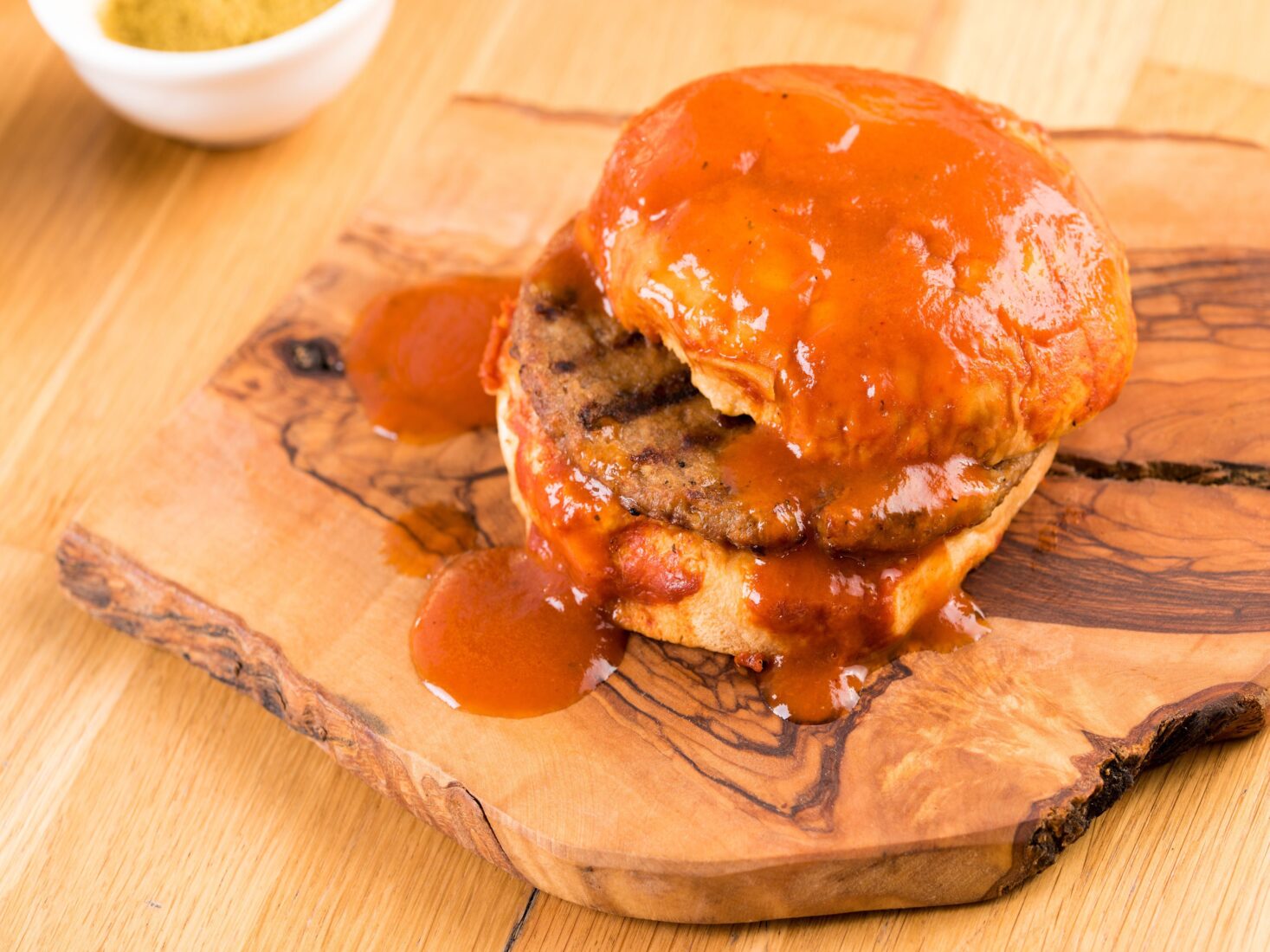 Delicious Turkish islak hamburger or wet burger on a wooden table. (Photo via Delivery Hero)