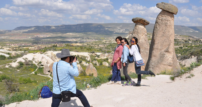 Japanese tourists pose for a photo in front of the famous fairy chimneys in Cappadocia, Türkiye, accessed on April 29, 2025. (IHA Photo)