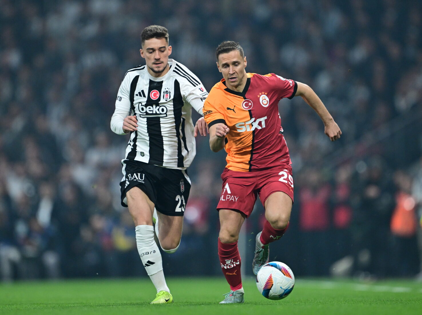 Przemyslaw Frankowski of Galatasaray in action against Ernest Muci of Besiktas during the Turkish Super Lig week 29 football match between Besiktas and Galatasaray at Tupras Stadium in Istanbul, Turkiye on March 29, 2025. (AA Photo)