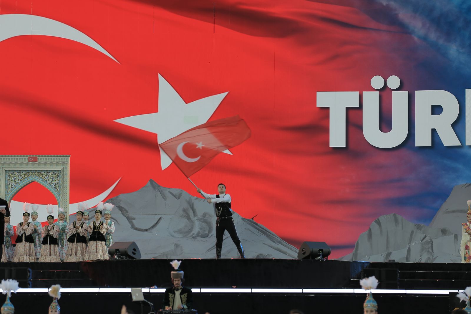 An artist from Türkiye on stage with a Turkish flag during the opening ceremony in Aktau, a city on the Caspian Sea coast of Kazakhstan, which was selected as the “2025 Cultural Capital of the Turkic World” by the International Organization of Turkic Culture (TURKSOY). (AA Photo)