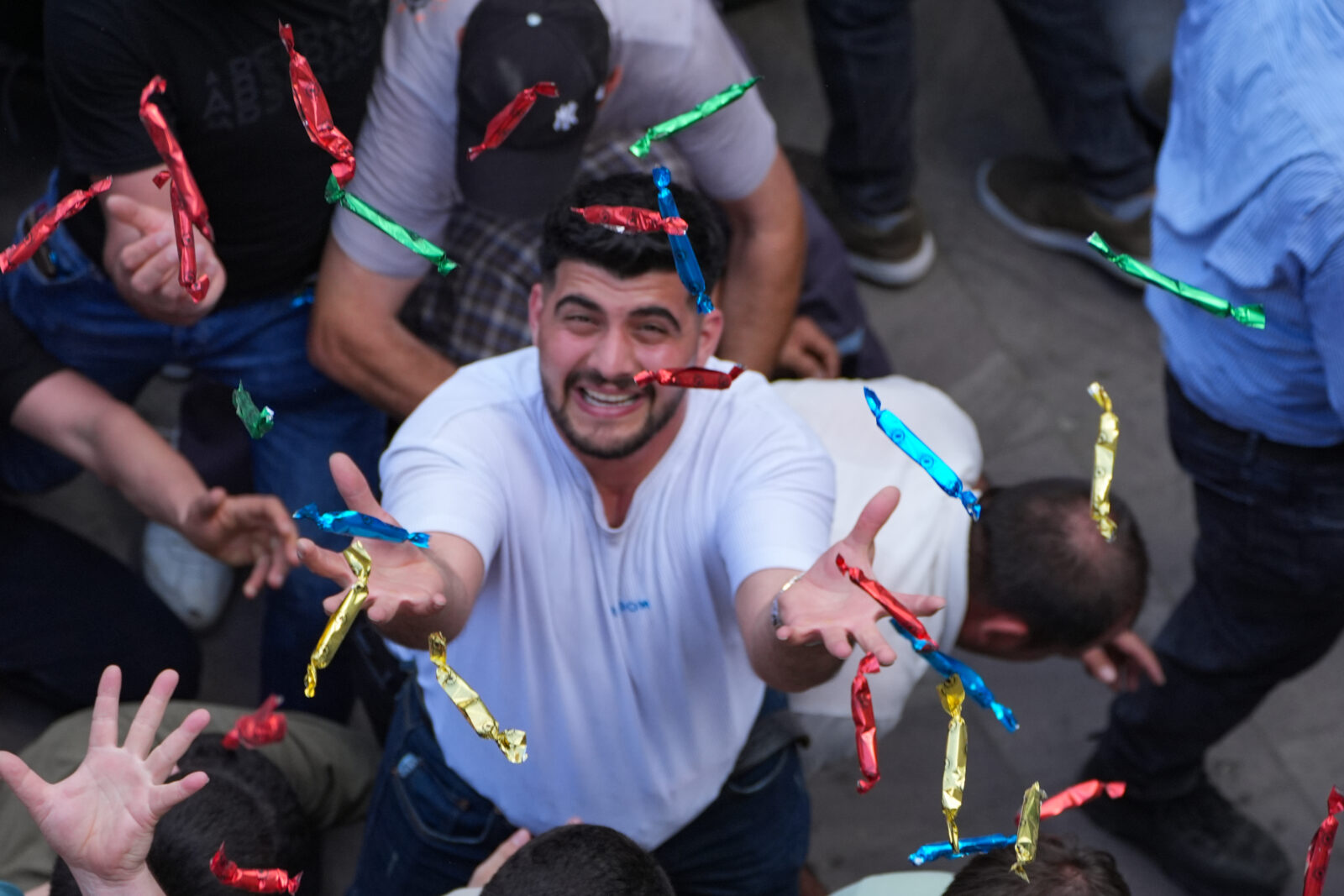 People try to catch the mesir paste bars thrown from the domes and minarets of the Sultan Mosque to the gathered public as part of the 485th International Manisa Mesir Paste Festival, Manisa, Türkiye, April 27, 2025. (AA Photo)