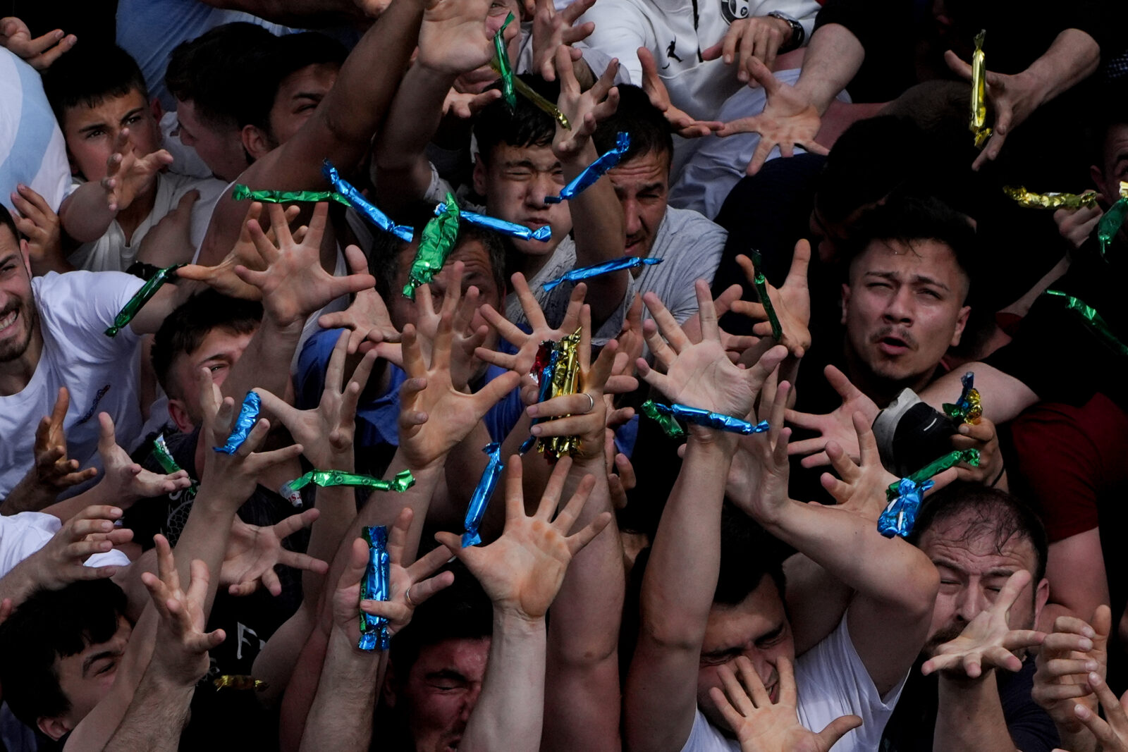People try to catch the mesir paste bars thrown from the domes and minarets of the Sultan Mosque to the gathered public as part of the 485th International Manisa Mesir Paste Festival, Manisa, Türkiye, April 27, 2025. (AA Photo)