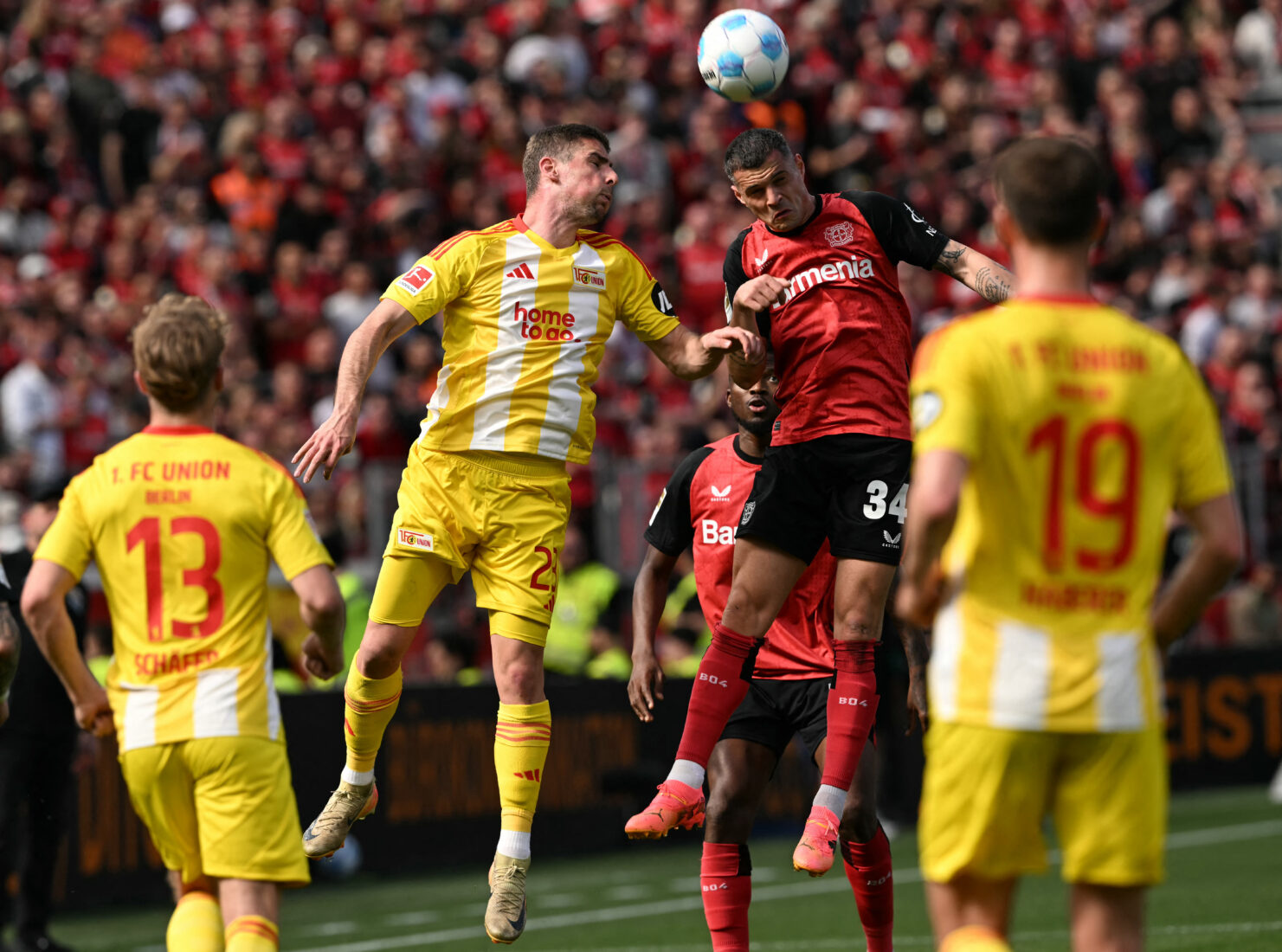 Union Berlin's Serbian forward #23 Andrej Ilic (L) and Bayer Leverkusen's Swiss midfielder #34 Granit Xhaka vie for the ball during the German first division Bundesliga football match between Bayer Leverkusen and Union Berlin in Leverkusen, western Germany, on April 12, 2025. (AFP Photo)