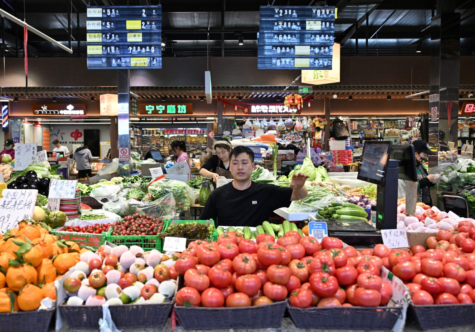 Vendors work at vegetable stalls at a market in Beijing on April 16, 2025. (AFP Photo)