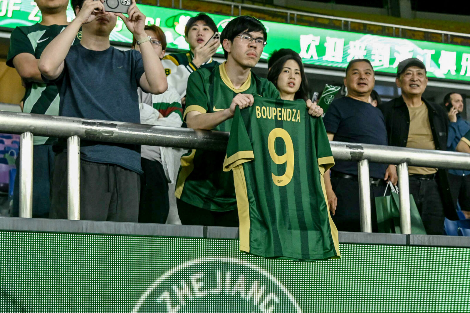 A fan holds a T-shirt with the name and number of Gabon international striker Aaron Boupendza during the Chinese Super League football match between Zhejiang FC and Meizhou Hakka in Hangzhou, in China's eastern Zhejiang province, on April 16, 2025. (AFP Photo)