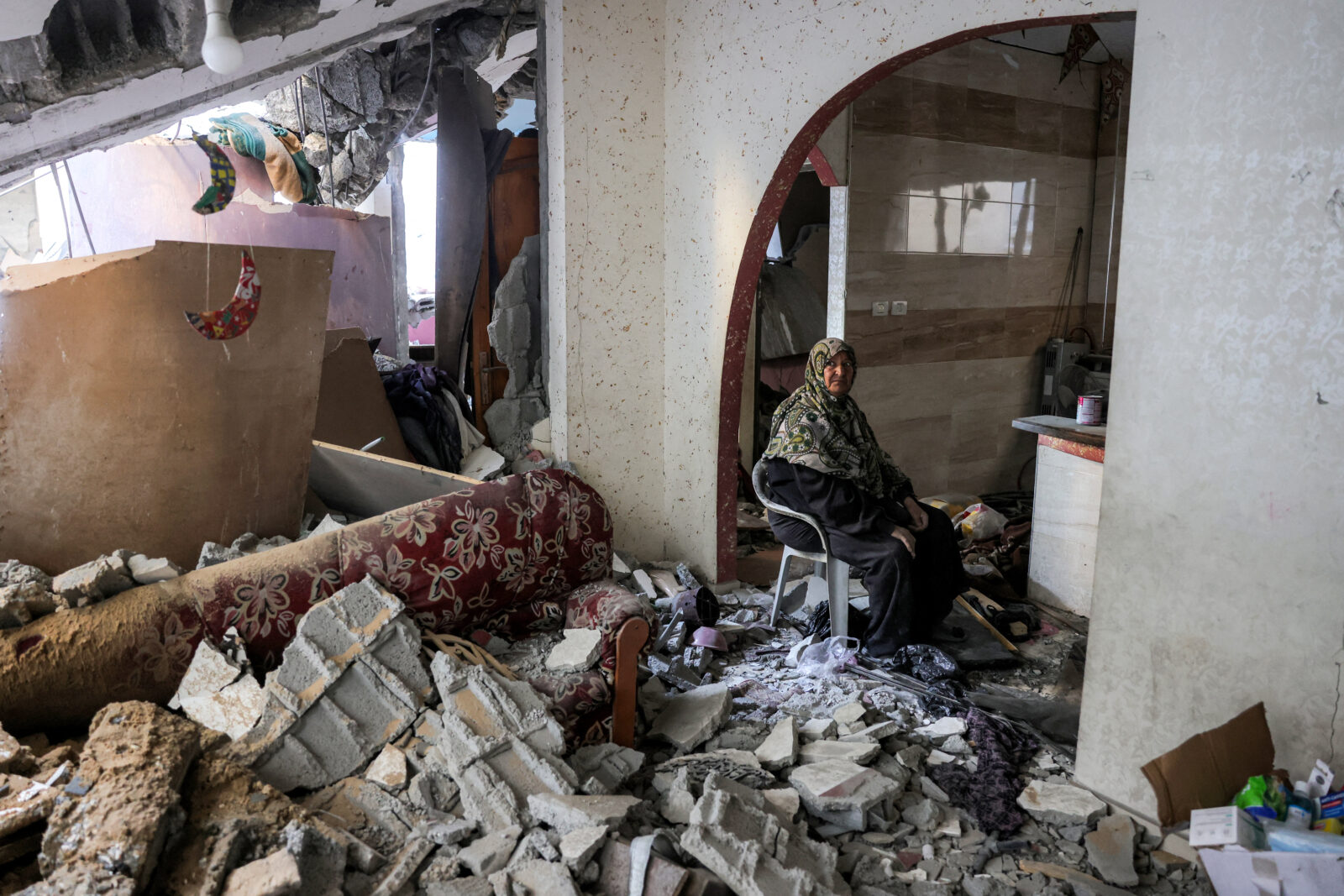 An elderly woman sits inside a damaged building that was hit by Israeli bombardment in Jabalia in the northern Gaza Strip on April 18, 2025. (AFP Photo)