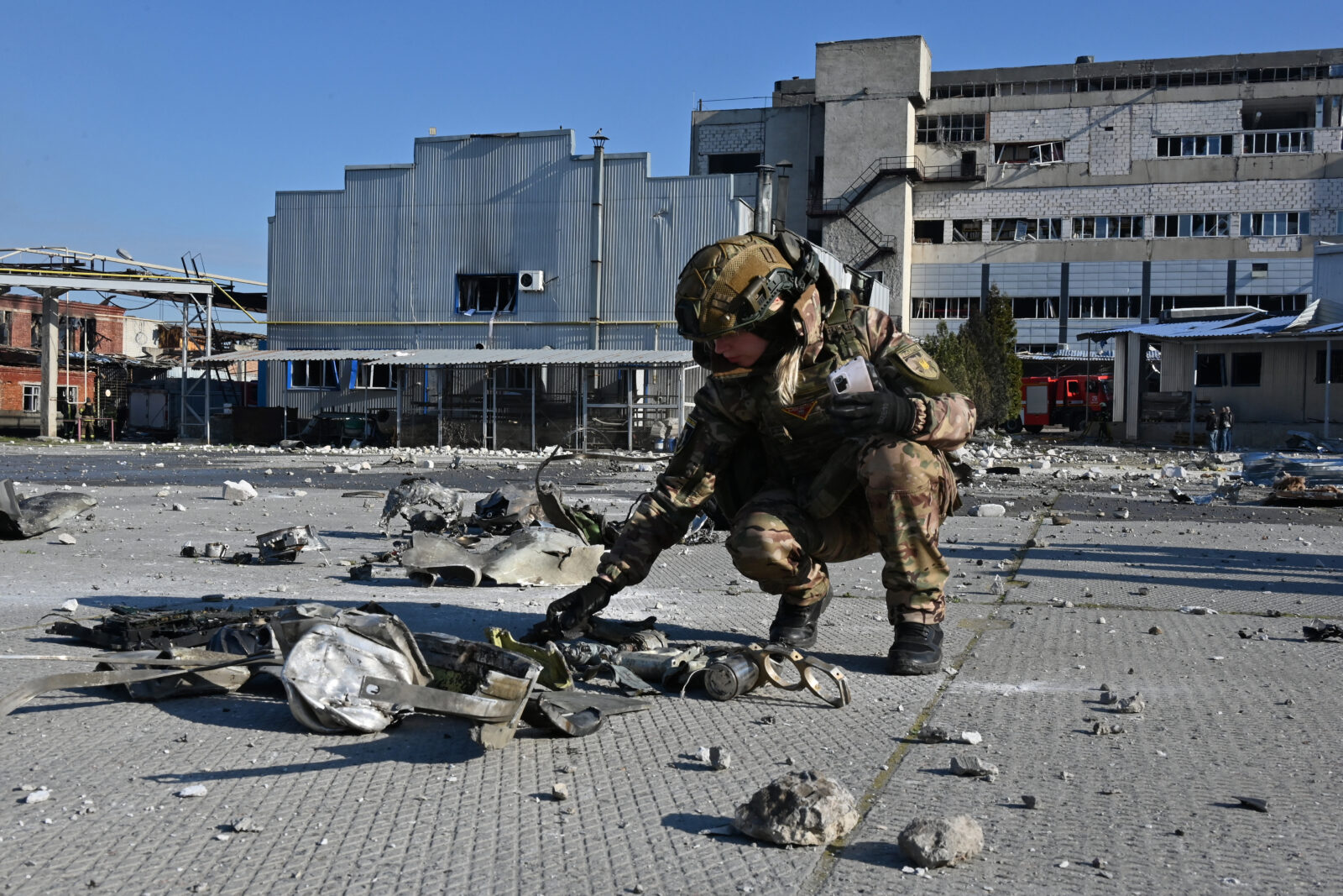 A Ukrainian law enforcement officer inspects the remains of a missile in front of a destroyed perfume and cosmetics manufacturing building following an attack in Kharkiv on April 18, 2025. (AFP Photo)