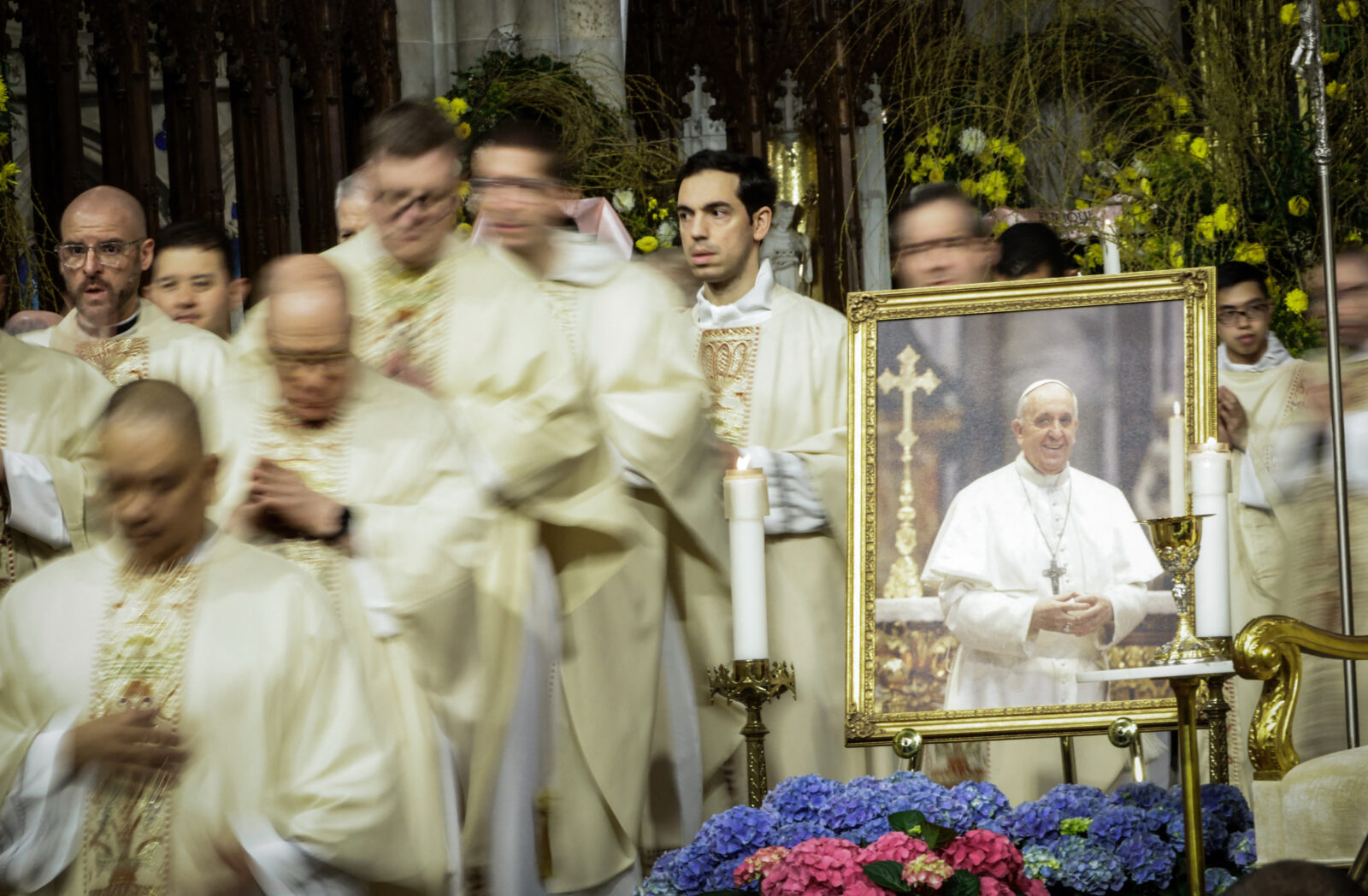 Clergy walk past a picture of the late Pope Francis during a mass at St. Patrick's Cathedral in New York, U.S., April 22, 2025 (AFP Photo)
