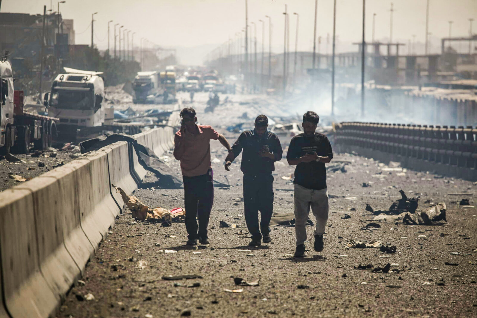 People use their telephones as they walk along a devastated boulevard following an explosion at the Shahid Rajaee port dock southwest of Bandar Abbas in the Iranian province of Hormozgan, Iran on April 26, 2025. (AFP Photo)