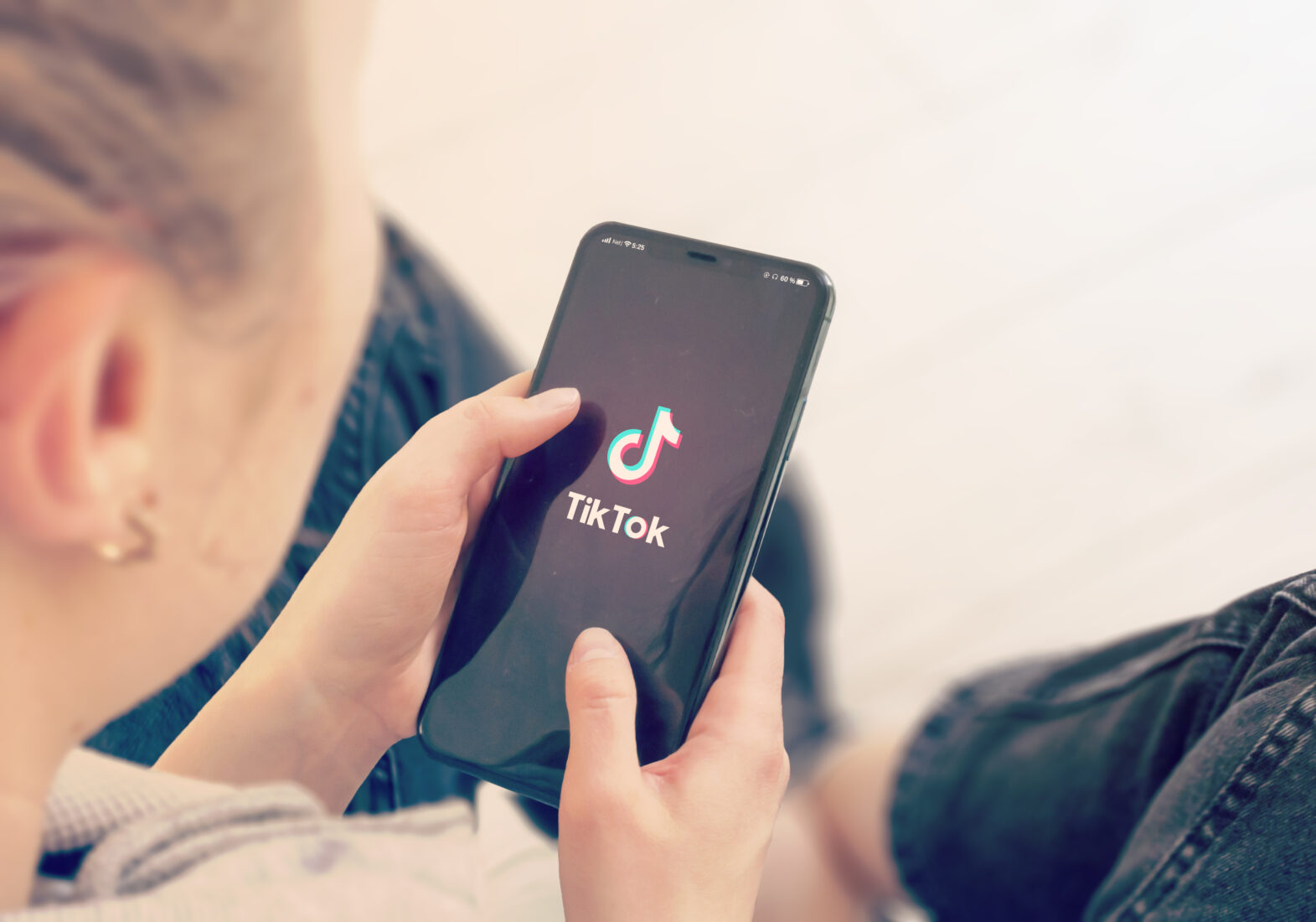Close-up of a hand holding a smartphone displaying the TikTok app, representing the growing influence of short-form video content on social media habits, accessed on April 26, 2025. (Adobe Stock Photo)