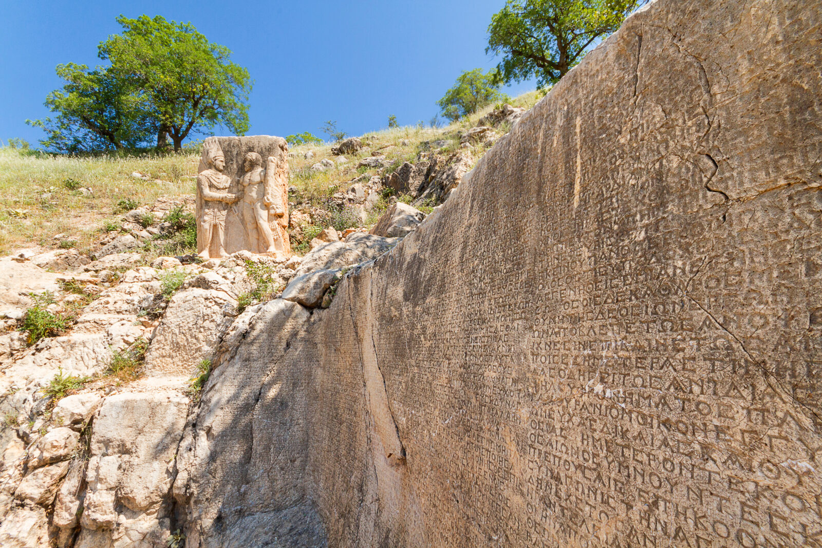 Türkiye's longest Greek inscription and the relief of Hercules and King Antiochus, of Commagene Kingdom in the ancient site of Arsemia, Mount Nemrut, Adiyaman, Türkiye. (Adobe Stock Photo)