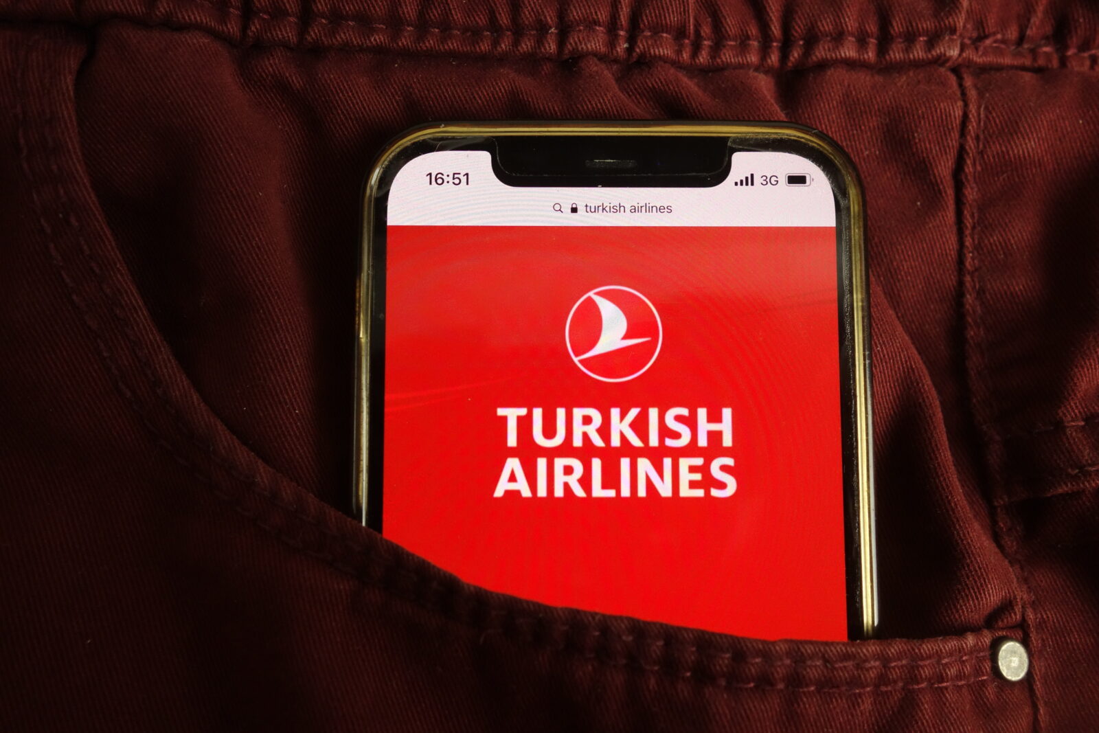 File photo shows a Turkish Airlines logo seen on a smartphone screen placed inside a pocket in Konskie, Poland, July 22, 2021. (Adobe Stock Photo)