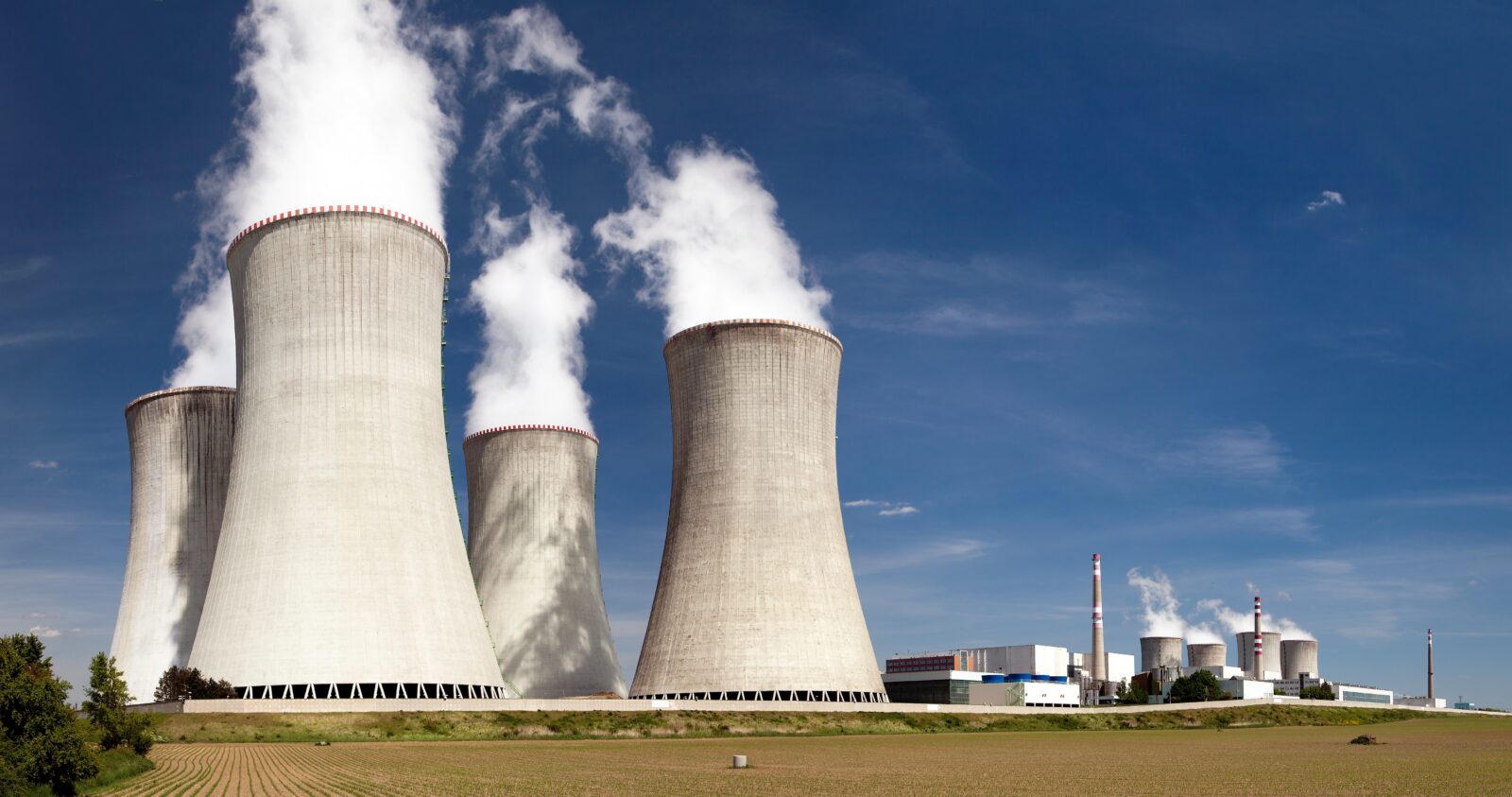 Nuclear power plant Dukovany - cooling towers, field, and beautiful sky - Czech Republic. (Adobe Stock Photo)