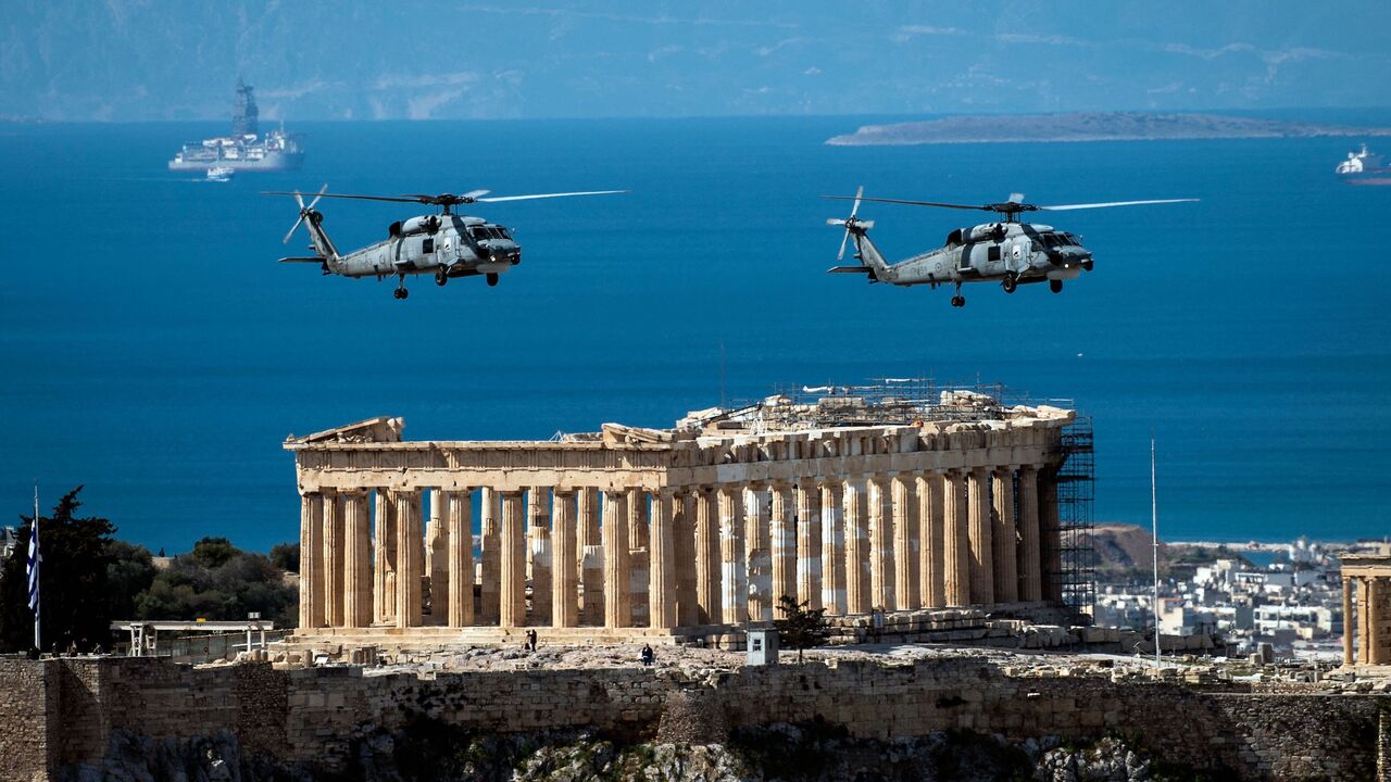 Greek Air Force helicopters fly over the Parthenon in Athens on March 25, 2021, as Greece celebrates its 200th anniversary of the 1821 revolution and war of independence. (Photo by ANGELOS TZORTZINIS / AFP) (Photo by ANGELOS TZORTZINIS/AFP via Getty Images)