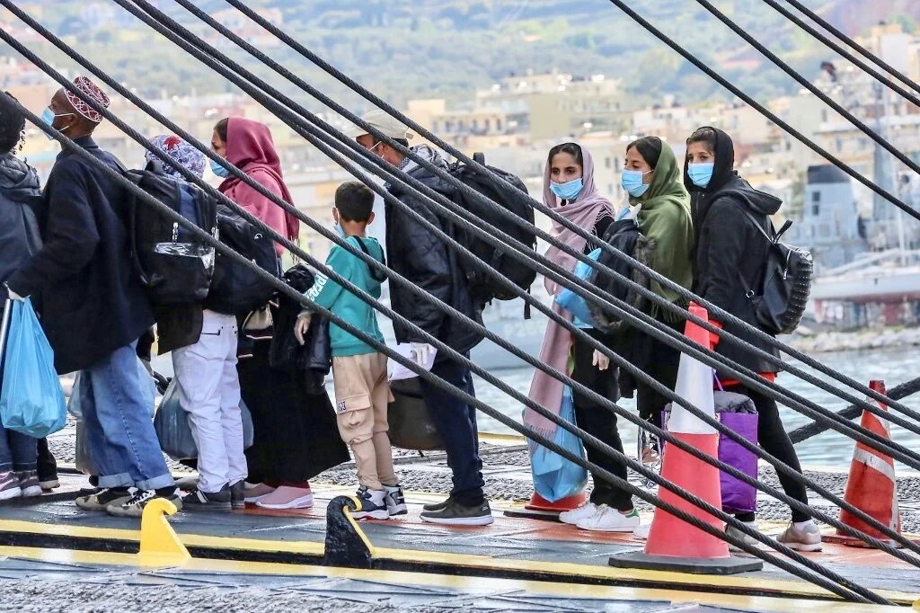 Migrants board a ferry at the port of Mytilene to be transferred from the island of Lesbos to the Greek main land on May 3, 2020 in Moria. - Greece transferred some 10,000 people to the mainland between January and March but the figure dropped to 627 across April to date, prompting Human Rights Watch to warn of a potential health crisis if camp decongestion is not stepped up. (Photo by Manolis Lagoutaris / AFP)