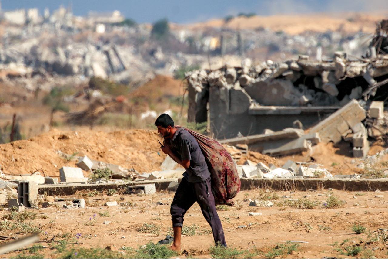 A man walks with humanitarian aid packages received from a distribution centre run at the so-called "Netzarim corridor", in Nuseirat central Gaza Strip, Sept. 30, 2025. (AFP Photo)