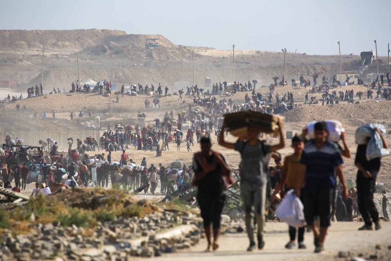 People walk with bags of humanitarian aid they received at a distribution centre run by GHF, at so-called  Netzarim corridor , in central Gaza Strip, Sept. 26, 2025. (AFP Photo)
