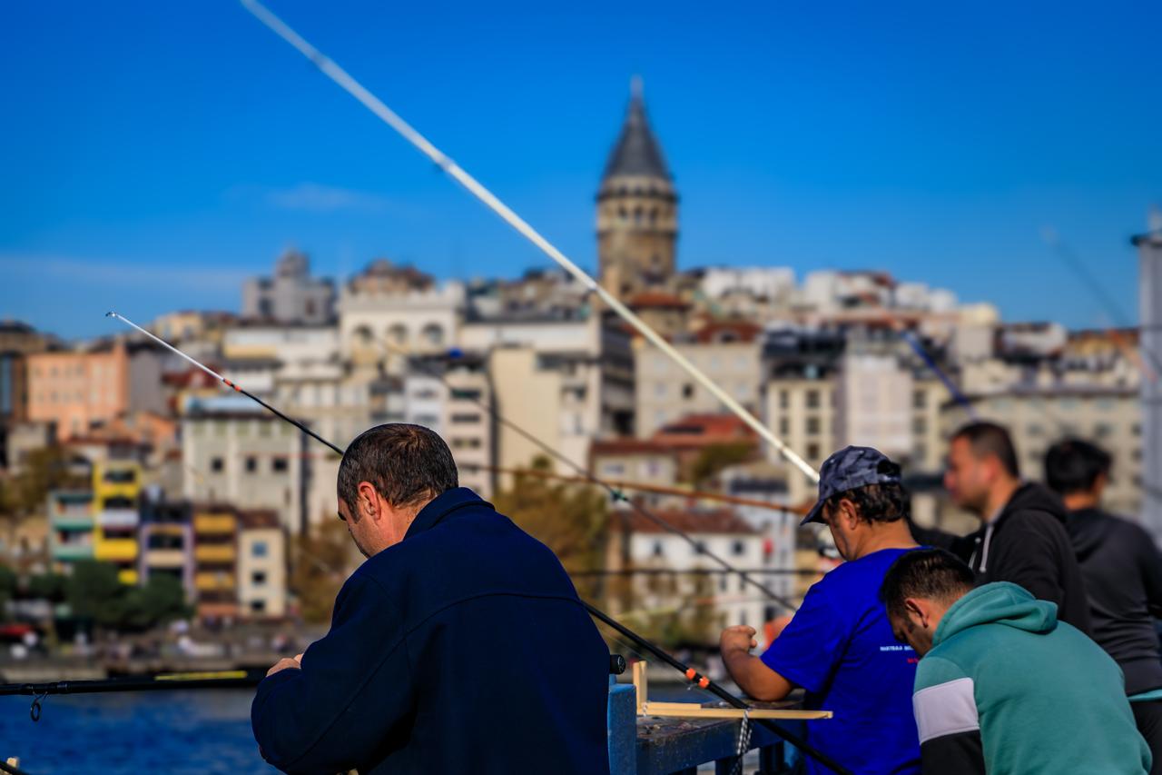 Fishermen cast their lines from Galata Bridge in Istanbul, Türkiye. (Adobe Stock Photo)