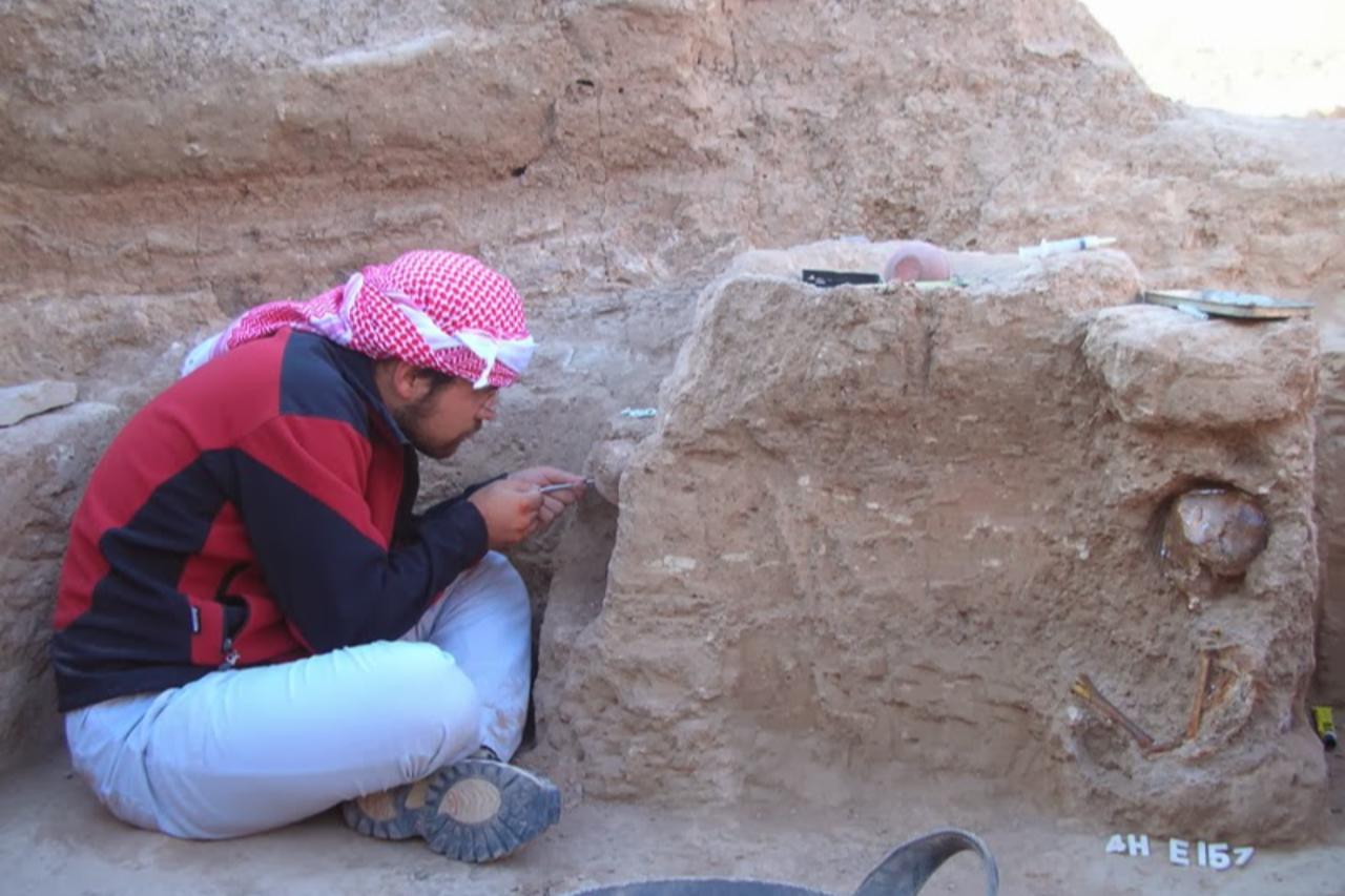 Archaeologist carefully excavating a Neolithic burial at Tell Halula, Syria, 2014. (Photo via Dental Ecology)