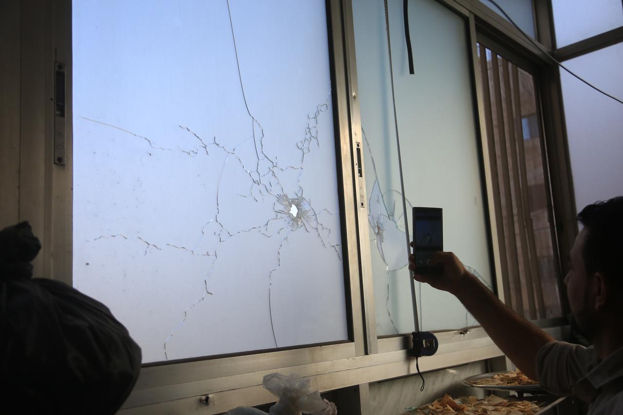 A Syrian man inspects windows that were hit by bullets during clashes between terrorist organization PKK/YPG, which operating under name SDF and Syrian security forces after ceasefire agreement in Aleppo, Syria, Oct. 7, 2025. (AA Photo)