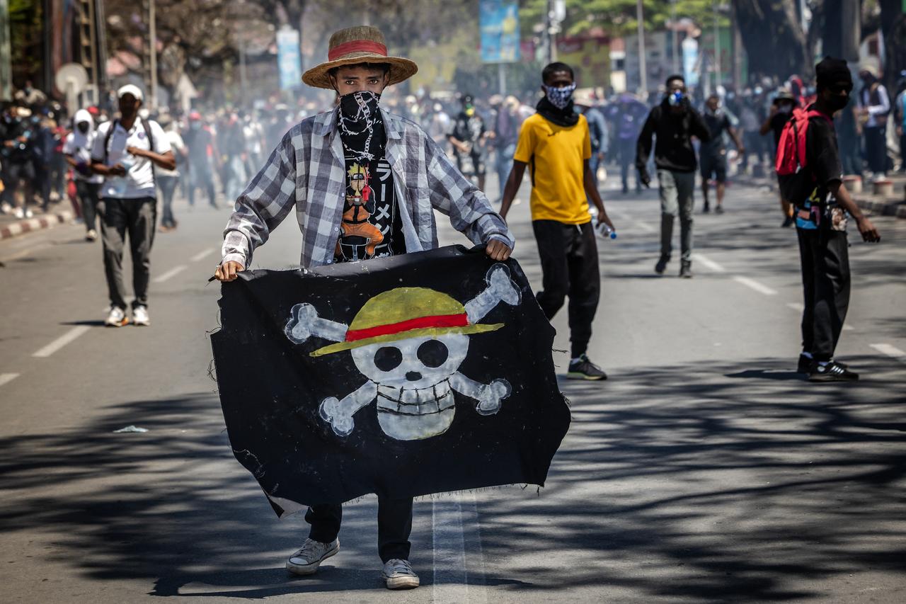 A student holds a flag bearing the logo of the popular Japanese manga One Piece, a symbol adopted by Gen Z protest movements worldwide, during clashes with Malagasy security forces amid a strike calling for constitutional reforms and the resignation of President Andry Rajoelina in Antananarivo, on October 9, 2025. (AFP Photo)