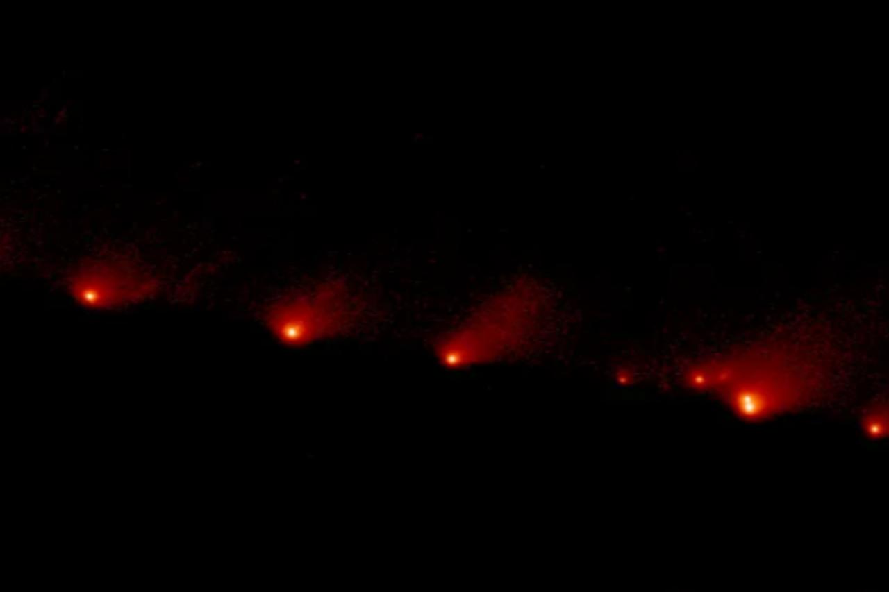The image shows a train of 21 icy fragments stretched across 1.1 million kilometers, torn apart by the tidal force of Jupiter A Hubble Space Telescope image of comet Shoemaker-Levy 9, taken on May 17, 1994. (Photo via NASA/ESA/STScI, H. Weaver and E. Smith)