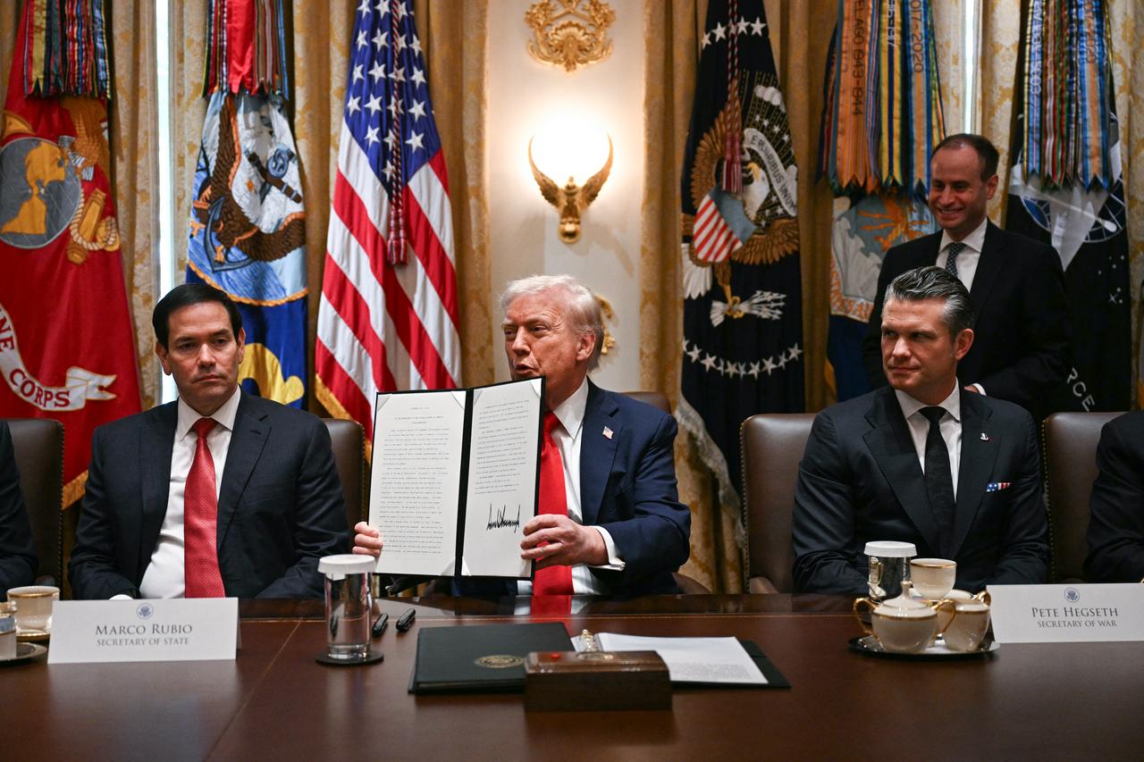 U.S. President Donald Trump (C) holds up signing documents recognizing days honoring Leif Erikson and Christopher Columbus while he speaks during a cabinet meeting, alongside Secretary of State Marco Rubio (L) and Secretary of Defense Pete Hegseth (R), in the Cabinet Room of the White House in Washington, on Oct. 9, 2025. (AFP Photo)
