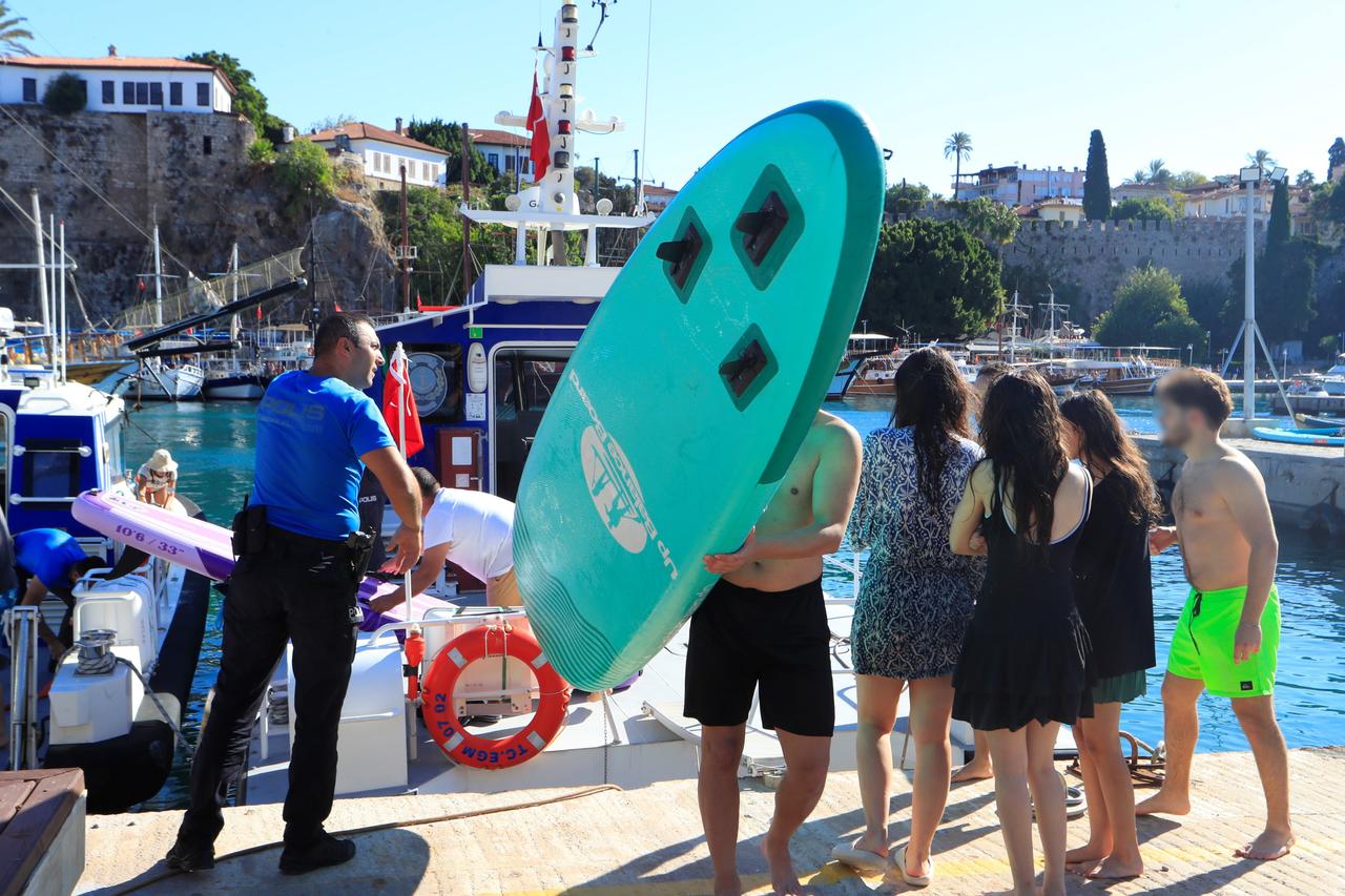 Deniz polisi tarafından kurtarıldıktan sonra Antalya Marina'ya dönen genç katılımcılar, 12 Ekim 2025. (IHA Fotoğrafı)