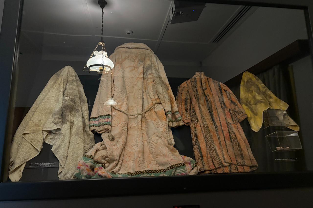 The coats and garments worn by Muruvvet Ilhan and her children are displayed inside the Museum of Barbarism, serving as silent witnesses to the 1963 ‘Bloody Christmas’ attacks, Oct. 10, 2025. (IHA Photo)