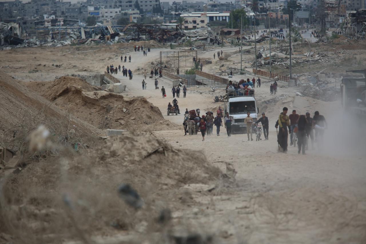 Palestinians, including children, continue heading north on the third day of the ceasefire in the Gaza Strip, carrying whatever belongings they could gather as they move along Salahaddin Street, connecting the south and north of the enclave, on Oct. 12, 2025. (AA Photo)