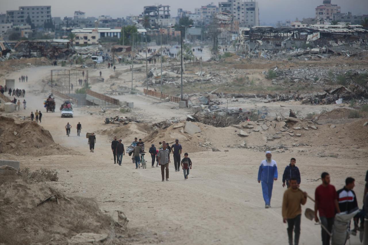 Palestinians, including children, continue heading north on the third day of the ceasefire in the Gaza Strip, carrying whatever belongings they could gather as they move along Salahaddin Street, connecting the south and north of the enclave, on Oct. 12, 2025. (AA Photo)
