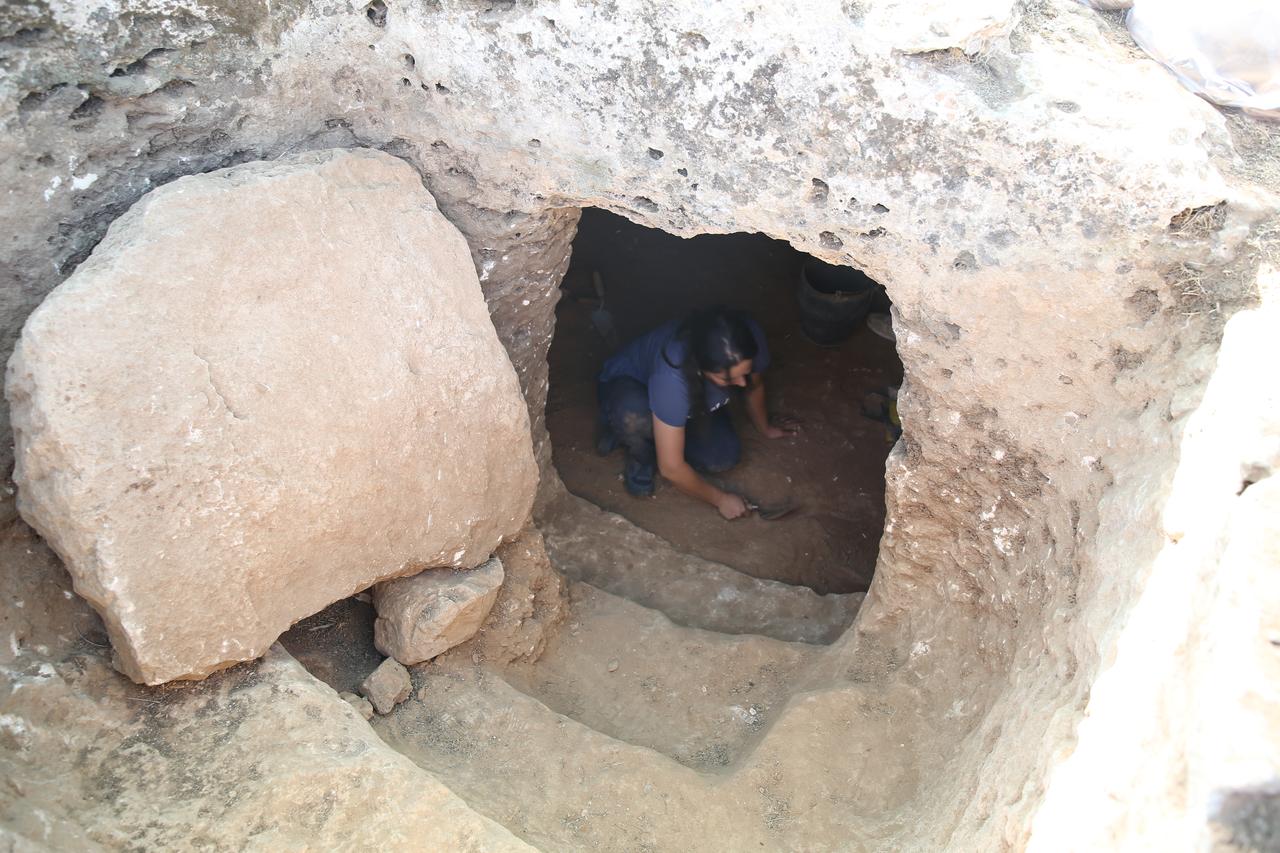 A researcher works inside a rock-cut burial chamber reached through a narrow entrance at ancient city of Sogmatar in Sanliurfa, Türkiye, Oct. 12, 2025. (AA Photo)