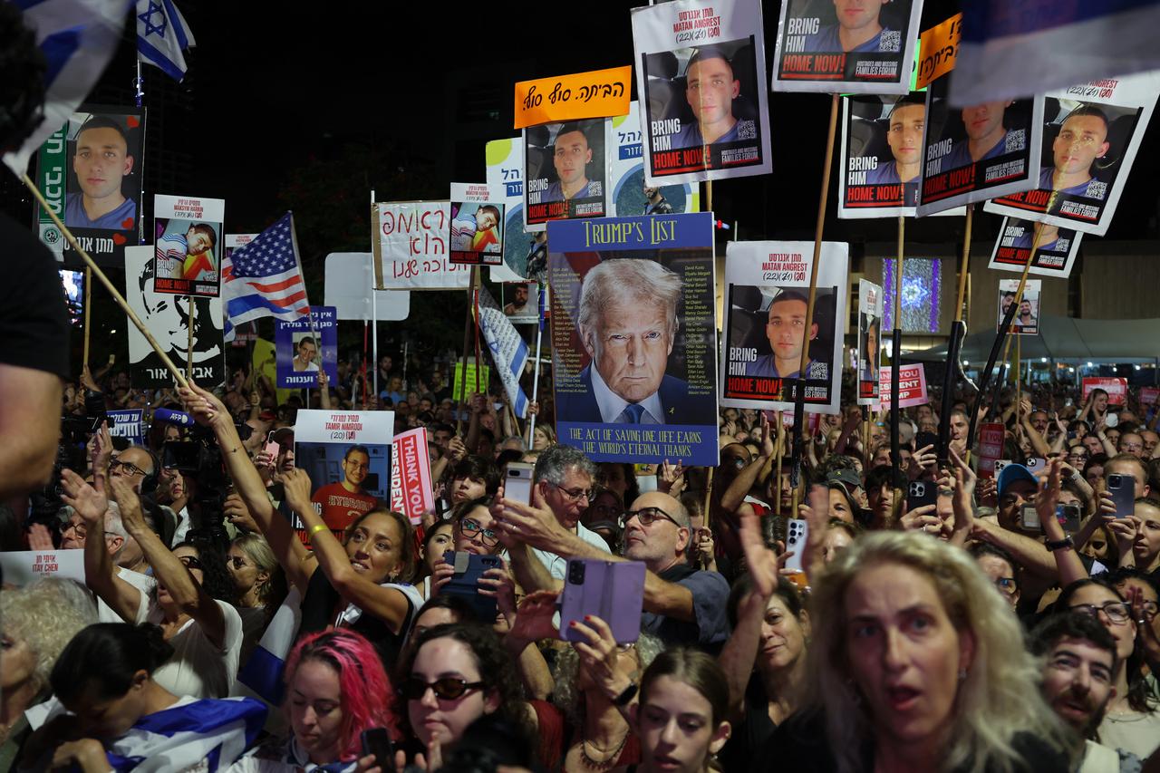 People wave Israeli and US flags during a gathering at Hostages Square in Tel Aviv on October 11, 2025. (AFP Photo)