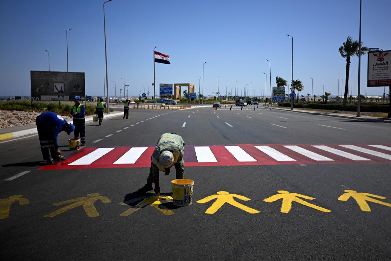Municipal workers paint markings on a road in Sharm el-Sheikh, following a Gaza ceasefire agreement, on October 11, 2025. (AFP Photo)