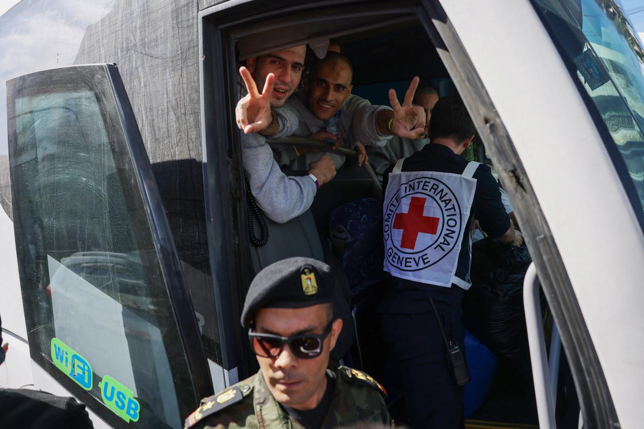 Palestinian men gesture from inside a bus after being released from the Ofer military prison located between Ramallah and Beitunia in the occupied West Bank on October 13, 2025 (AFP Photo )