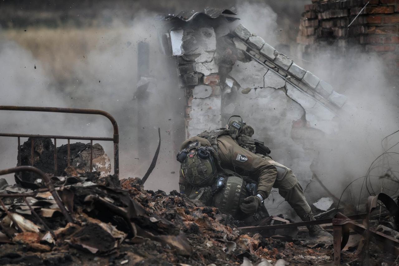 Infantry recruits of the 28th Seperate Mechanized Brigade take cover from a grenade blast as they undergo a basic training course at an undislosed location in eastern Ukraine on Oct. 9, 2025. (AFP Photo)
