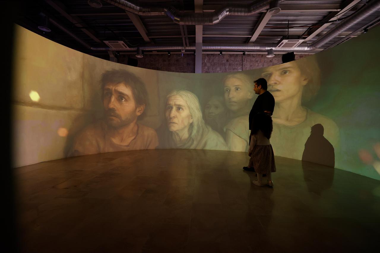Visitors watch a projection illustrating ancient life at the newly opened Arslantepe Hoyuk Welcome Center in Malatya, Türkiye, Oct. 12, 2025. (AA Photo)