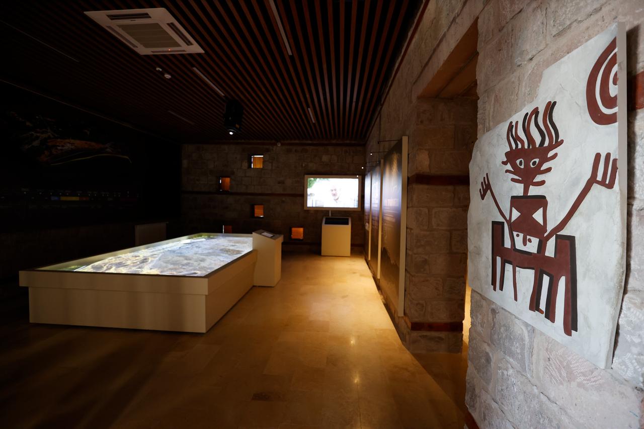 Interior view of the Arslantepe Hoyuk Welcome Center’s multimedia exhibition space, featuring digital maps and symbolic wall art, Malatya, Türkiye, Oct. 12, 2025. (AA Photo)