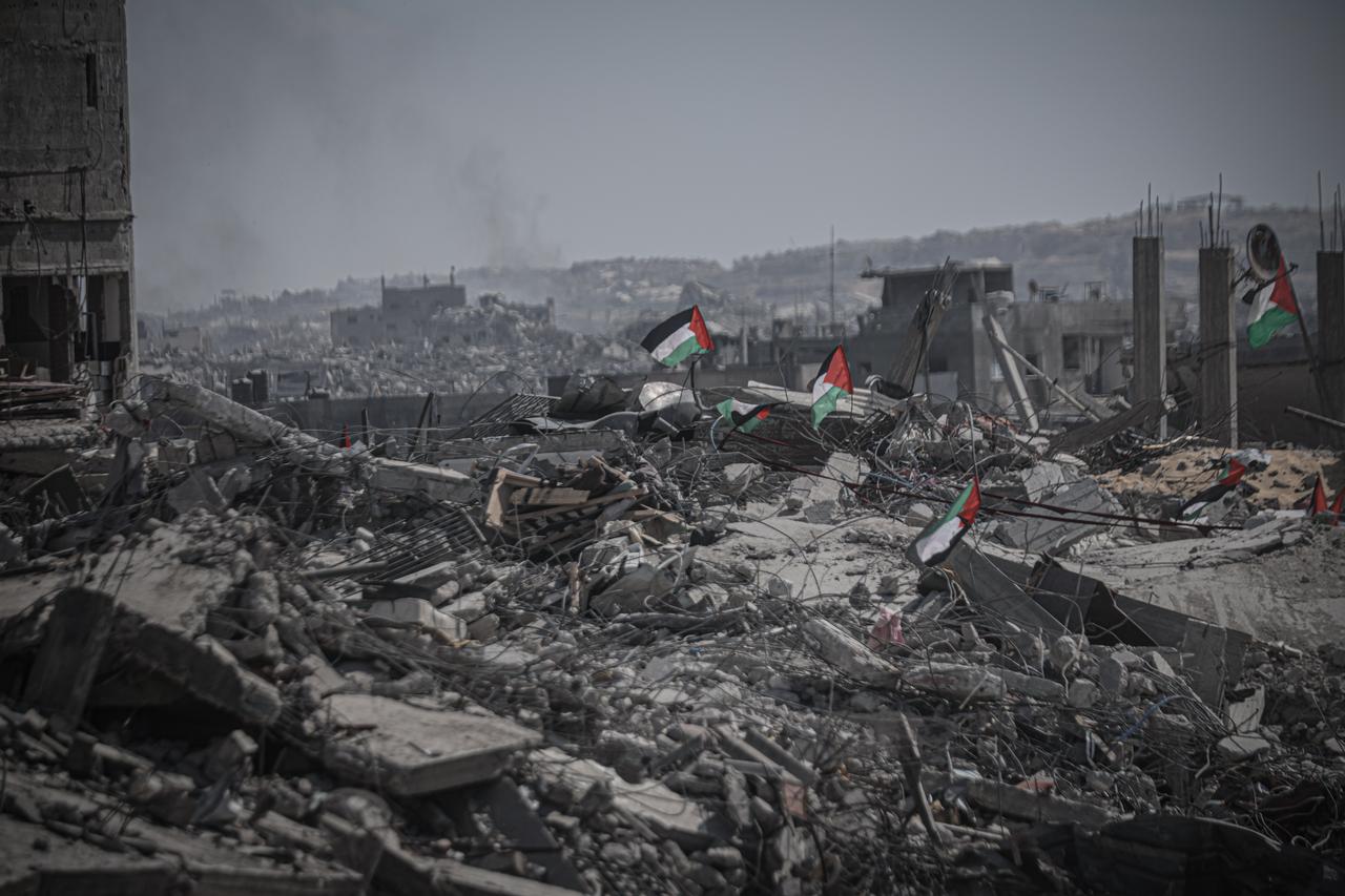 Palestinian flags are seen among the rubble of destroyed buildings as residents continue to return to northern Gaza following the ceasefire, October 13, 2025. (AA Photo)