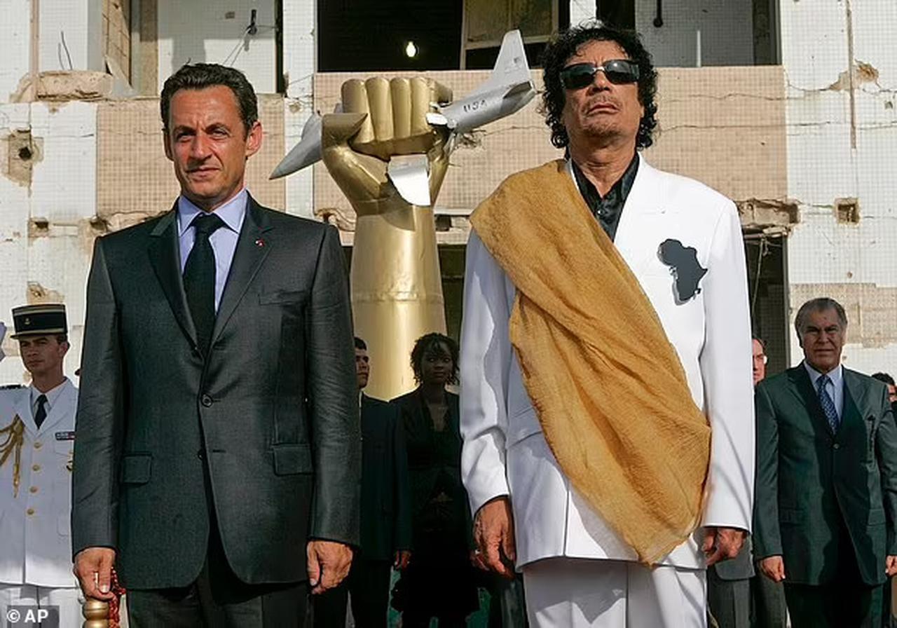 Late Libyan leader Moammar Gadhafi (right) and then French President Nicolas Sarkozy are pictured during the National anthems at the Bab Azizia Palace in Tripoli, July 25, 2007. (Photo via Daily Mail)