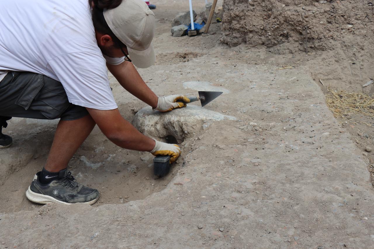 An archaeologist carefully cleans a section of the newly discovered drainage system at the Roman theater of Nicaea (modern-day Iznik) in Türkiye’s Bursa province, Oct. 13, 2025. (AA Photo)