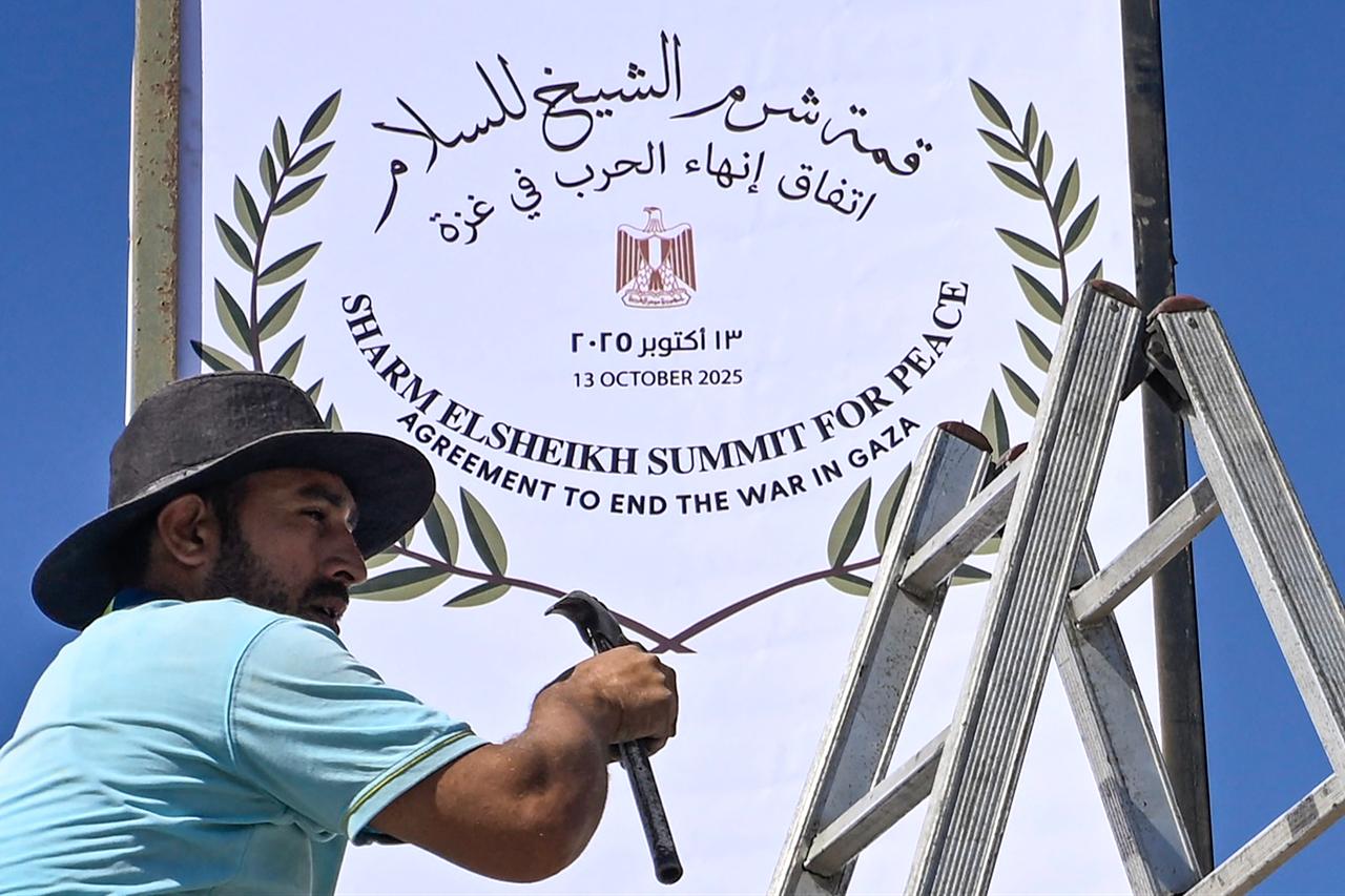 A municipal worker fixes a sign in Sharm el-Seikh, as the Egyptian resort town gets ready to host a US-brokered Gaza peace summit, on October 12, 2025. ( AFP Photo)