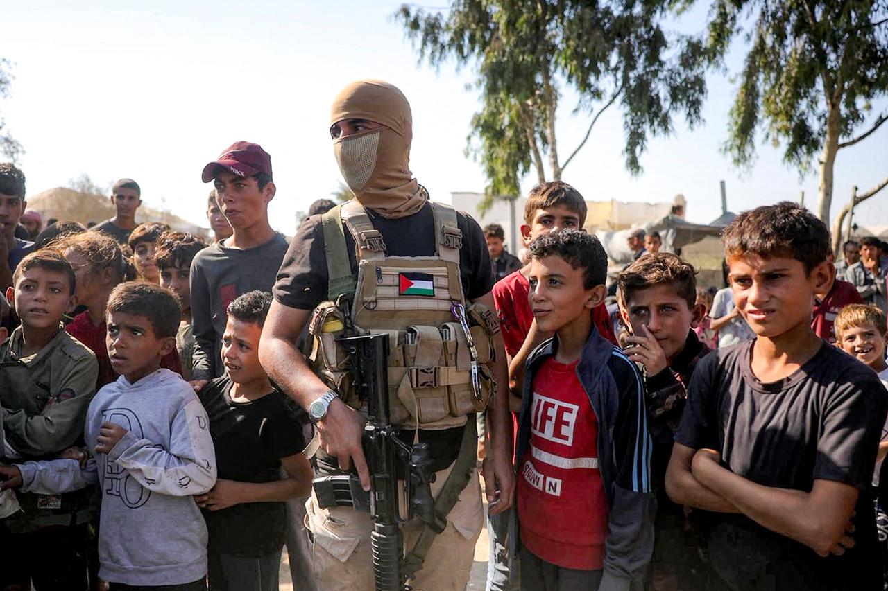 A masked fighter of Izzedine al-Qassam Brigades, armed wing of Hamas, stands guard before arrival of vehicles of the ICRC in central Gaza Strip, Oct. 13, 2025. (AFP Photo)