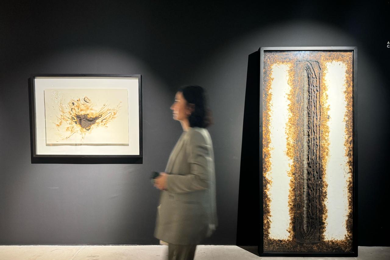 A guest walks past artworks displayed in one of the galleries participating in the 12th Artweeks Istanbul, showcasing painting, sculpture, and mixed media, Oct. 15, 2025. (AA Photo)