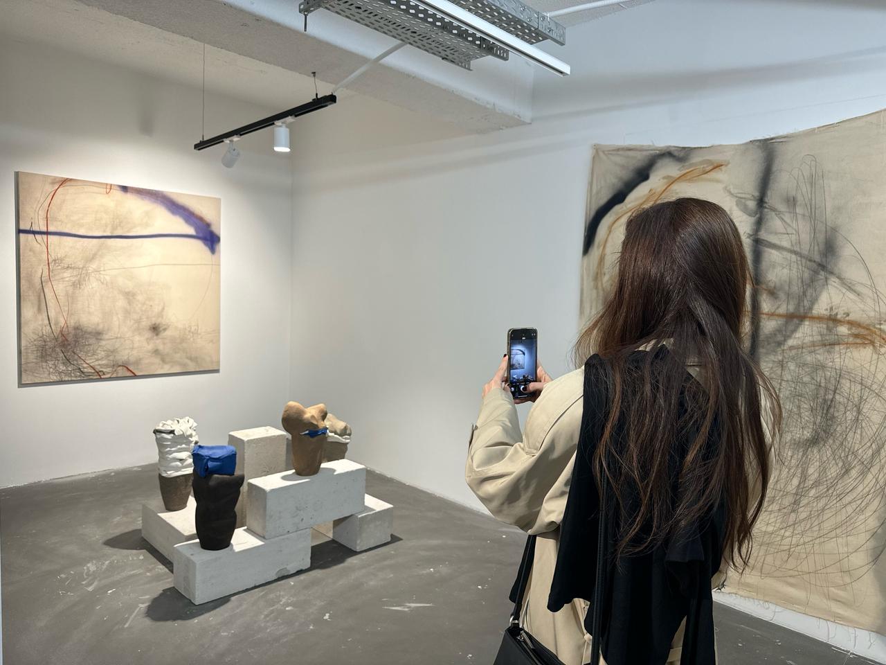A visitor photographs ceramic installations and abstract works exhibited as part of Artweeks Istanbul’s multidisciplinary program, Oct. 15, 2025. (AA Photo)