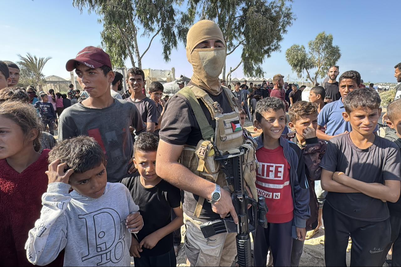 A masked fighter of Izzedine al-Qassam Brigades, armed wing of Hamas, stands guard before arrival of vehicles of the ICRC in central Gaza Strip, Oct. 13, 2025. (AFP Photo)