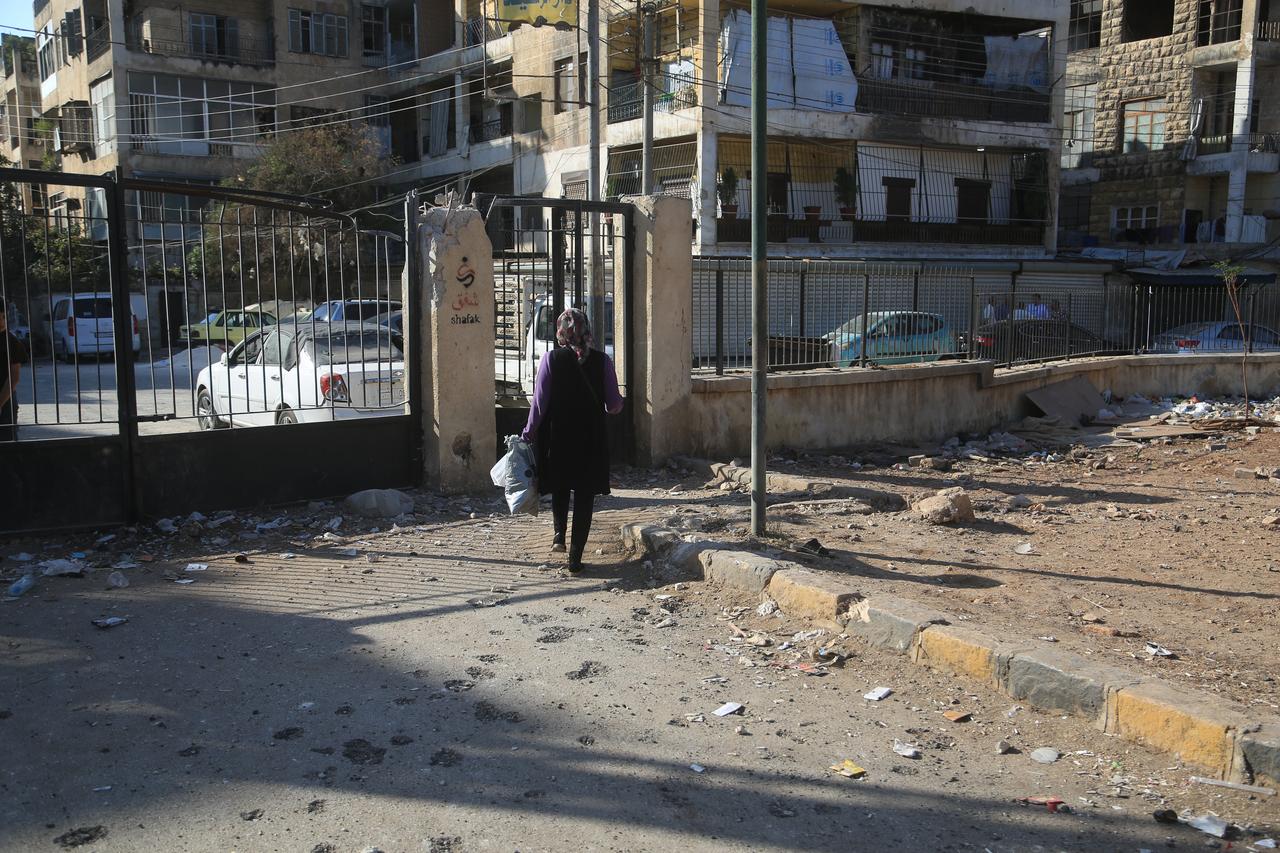 A woman walks near settlements damaged during the clashes between the terrorist organization PKK/YPG, which operating under the name SDF, and Syrian security forces after ceasefire agreement in Aleppo, Syria on Oct. 07, 2025. (AA Photo)